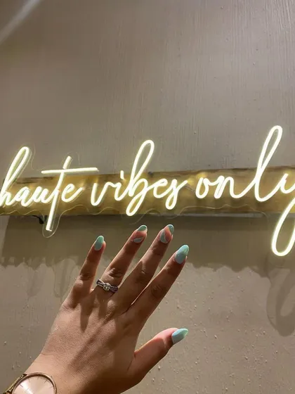 Nothing beats the feeling of fresh nails. Here’s a look at a beautiful mint green manicure, perfectly captured against our signature "haute vibes only" neon sign.