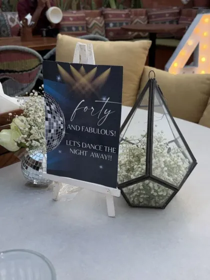 Fun and cheeky signage for a 40th birthday, like this 'Forty and Fabulous' card, adds a playful touch to the table decor.