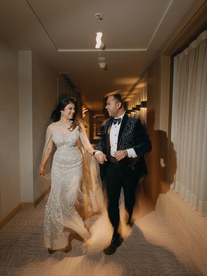 A candid shot filled with motion and happiness. The slight motion blur conveys the energy and excitement of the evening as the couple walks hand-in-hand, sharing a joyful moment.
