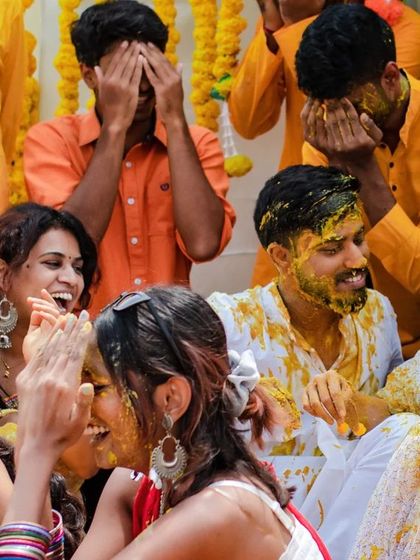A close-up of the happy chaos during a Haldi ceremony. We capture the genuine laughter and fun as friends and family join in the celebration.