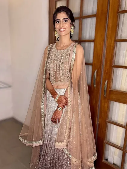 A full-length shot showing how the entire look comes together, from the elegant hairstyle to the glowing makeup.