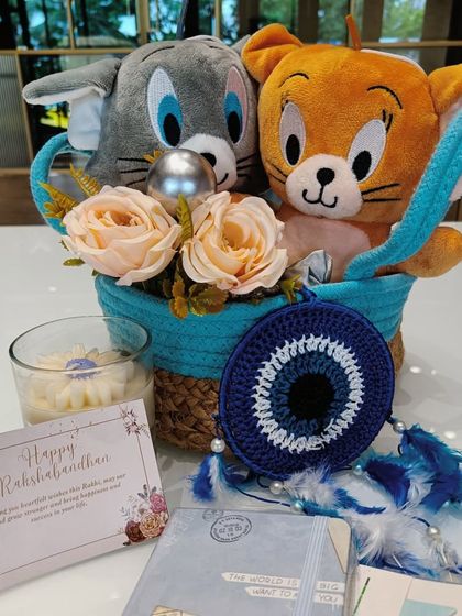 This Tom and Jerry themed hamper is for that classic love-hate sibling relationship. It features cute plushies, a scented candle, an evil eye dreamcatcher for protection, and a personalized Rakshabandhan card.