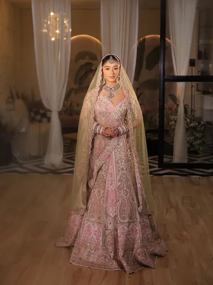 The bride looking regal in her pink lehenga with a sheer veil. This is how you blend tradition with modern style.