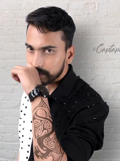 A modern male portrait with an intense, direct gaze. This headshot, taken against a white brick studio wall, focuses on expression and is perfect for building a diverse acting or modeling portfolio.