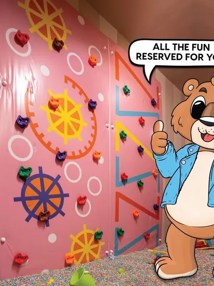 All the fun is reserved for you! Our play area includes engaging features like this colorful climbing wall, designed to challenge and entertain kids in a safe environment.
