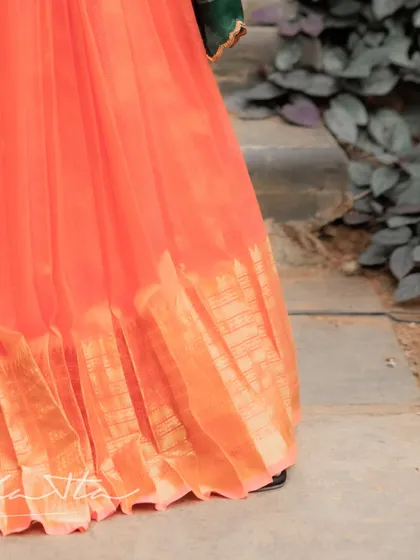 Another view of the pleated orange skirt, highlighting the beautiful fall of the Mangalagiri silk.