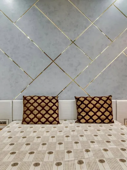 A direct view of the elegant headboard wall. The subtle texture of the grey panels contrasts beautifully with the metallic gold lines, creating a sophisticated focal point.
