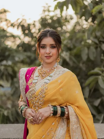 This portrait captures the bride's poise and pride. The makeup is designed to feel timeless, with kohl-rimmed eyes that speak volumes and skin that glows with a soft light.