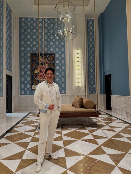 A clean, all-white look in a stunning, modern Indian hotel lobby. The aesthetic of the venue often inspires the vibe of the party.