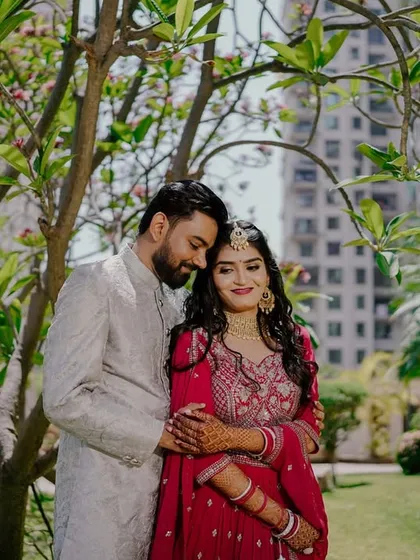 An intimate embrace in a sun-dappled garden. This portrait captures a quiet, romantic moment away from the crowds, focusing solely on the couple's connection.