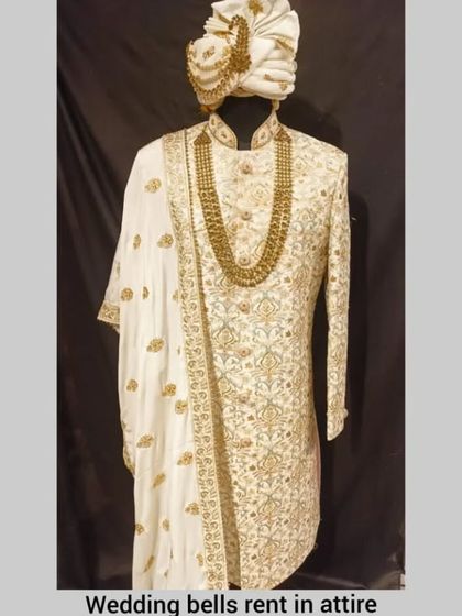 A full view of the off-white and gold embroidered sherwani, showcasing its regal design. This is a perfect rental choice for a groom seeking a classic and elegant look.