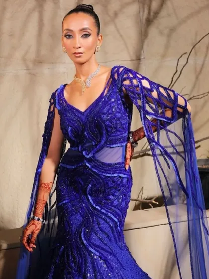 An embellished lehenga in a stunning blue hue, with floor-sweeping sleeves that add an ethereal, regal touch. A statement of grace and power.