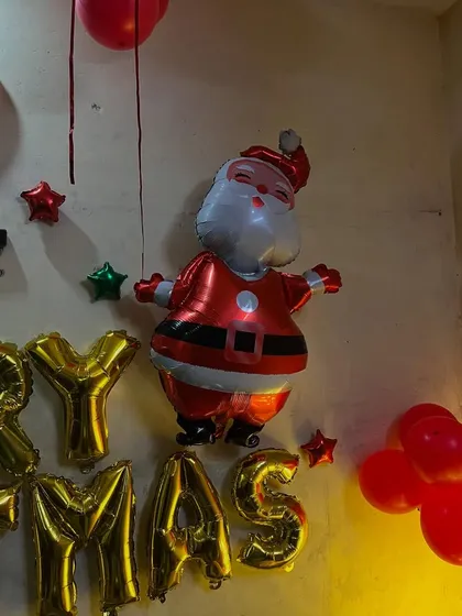 A close-up of a Santa Claus foil balloon, part of a simpler home decoration.