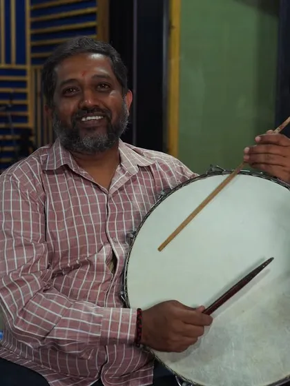 One of our folk percussionists with a huge smile, holding his drum. This image perfectly captures the joy and pride of the artists who share their traditional art with us.