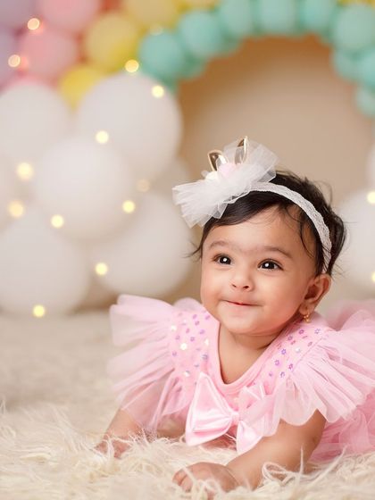 Wrapped in love, filled with joy. This half-birthday shoot with a pastel rainbow backdrop celebrates six months of sweetness.