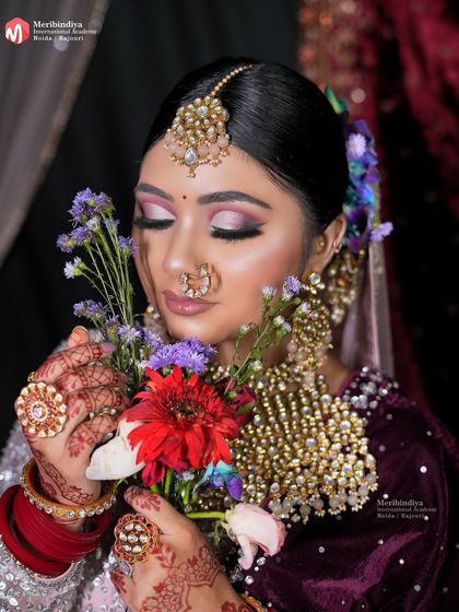 This pose with flowers adds a soft, natural element. I teach how to balance makeup with accessories and props for beautiful, timeless photos.
