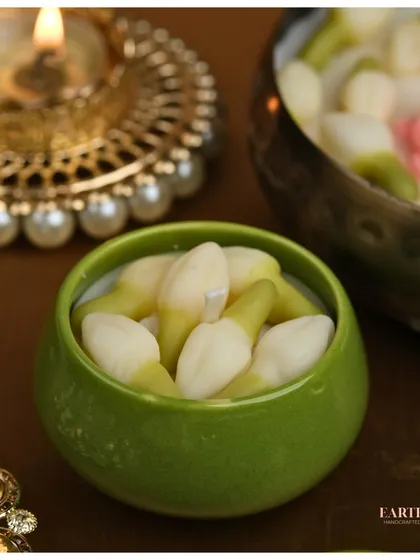 A beautiful jasmine bud candle in a green ceramic bowl, perfect for festive decor.