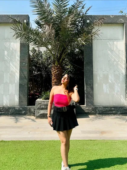 A bright and bold look with a hot pink tube top and a black pleated skirt. This outfit is confident and eye-catching.