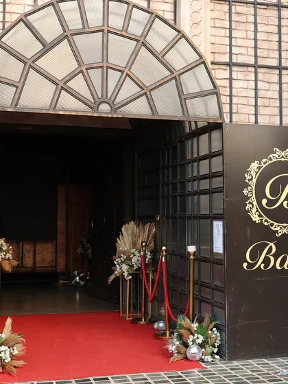 The entrance to the club event, featuring a red carpet and elegant floral arrangements to welcome guests in style.