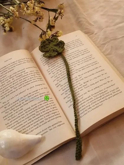 The four-leaf clover bookmark resting inside a book. Its simple, elegant design makes it a meaningful and beautiful page holder.