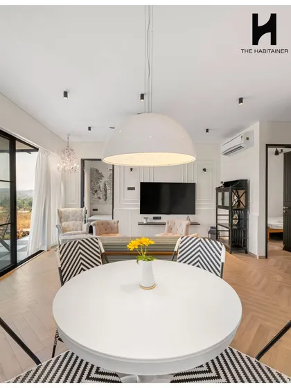 Step inside a chic prefab home we designed in Denkanikotta. This view of the open-plan living and dining area highlights the warm, elegant, and comfortable interiors we can create, proving that modular construction offers complete design freedom.