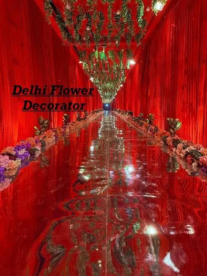I love creating dramatic entrances. For this wedding, we used a reflective mirror-finish carpet, lush red draping, and a ceiling of hanging greenery to give guests an unforgettable walk-in experience.