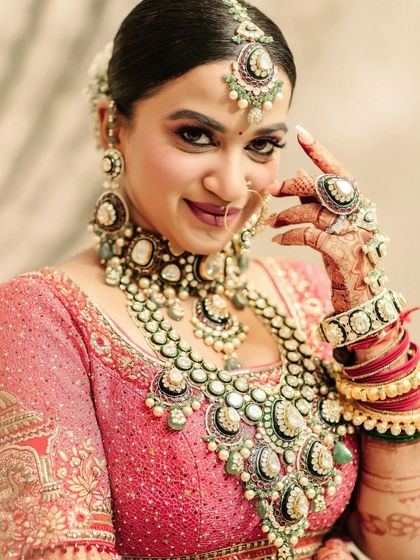 A close-up of the bride showing off her magnificent jewelry and henna-adorned hand, a perfect shot for detail lovers.