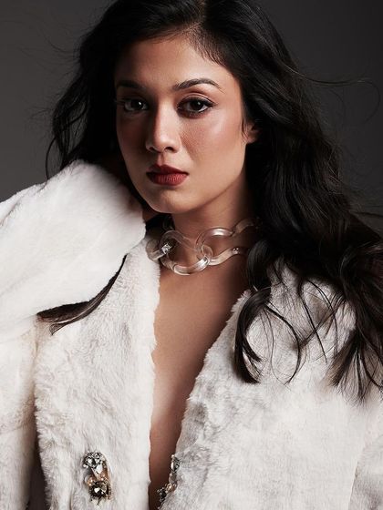 A close-up on the model's expression, with her hair styled to create a soft, dynamic frame.