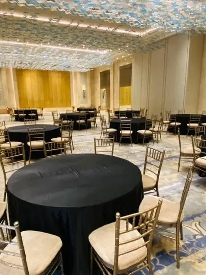 We take care of the entire setup, including tables and chairs. This is the dining area we arranged for a house warming at Lodha World Towers, with elegant black linens and chiavari chairs.