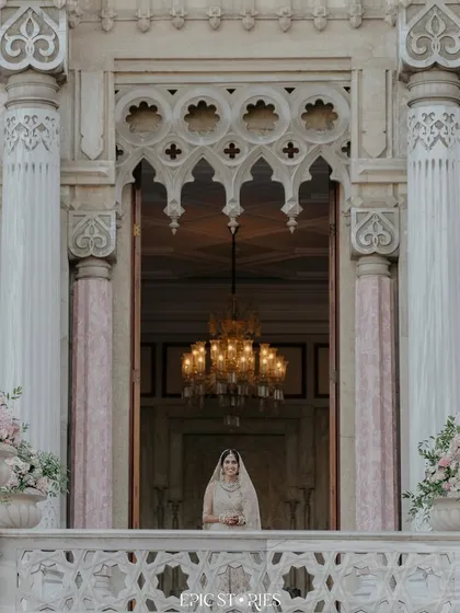 The bride appearing on the balcony of the magnificent Ciragan Palace in Istanbul. This shot captures a sense of royal grandeur and anticipation, a truly cinematic moment.