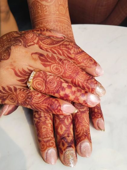 A close-up of a subtle cat-eye gel polish on natural nails. This is a great option for a bride or bridesmaid who wants a touch of sparkle that complements their intricate henna without being overpowering.