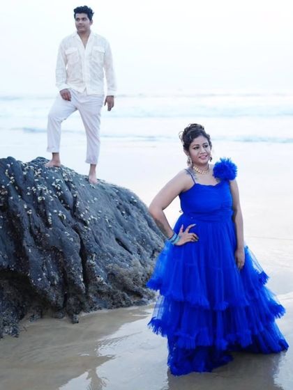 This beach pre-wedding photo has a relaxed yet stylish feel. The client's tiered blue gown looks beautiful against the ocean backdrop.