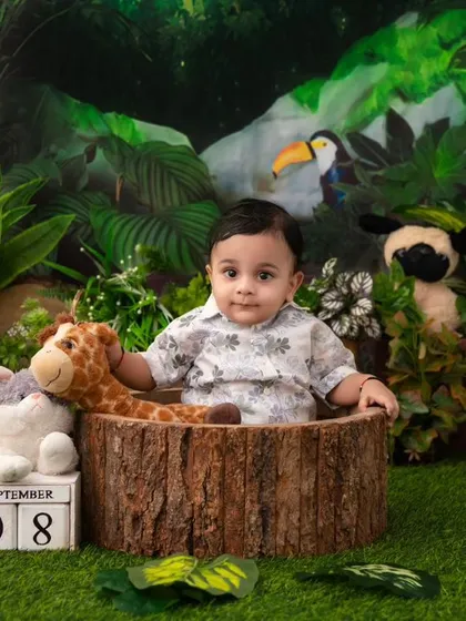 A jungle adventure. This little one is surrounded by his favorite safari animals in a lush, green jungle setting.