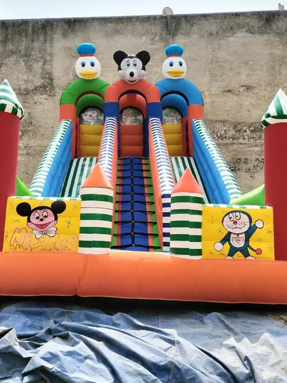 A 14x23 foot 3-slider bouncy with hand-painted style Mickey and Doraemon characters on the front pillars.
