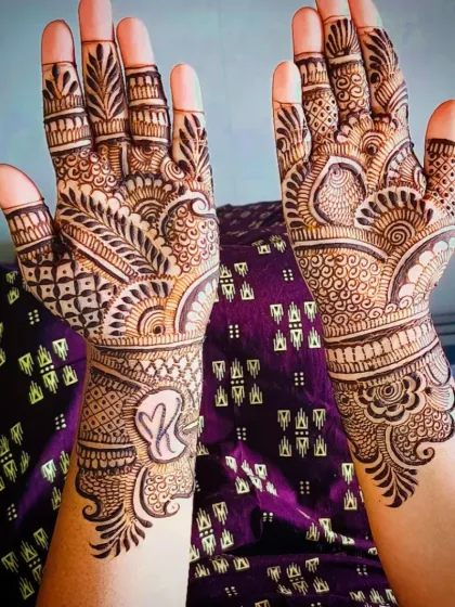 Another angle of the "K" initial mehandi, showing the full design on both hands.