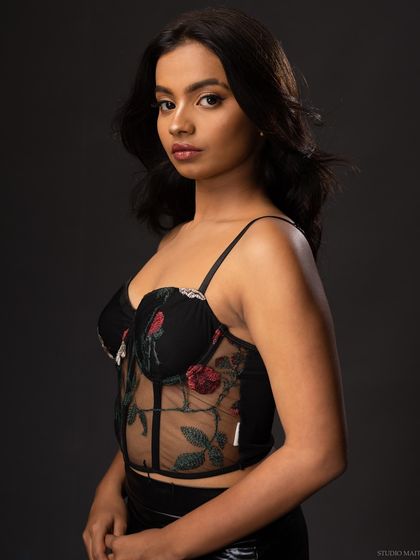 A classic three-quarter portrait of a model in a floral corset top.