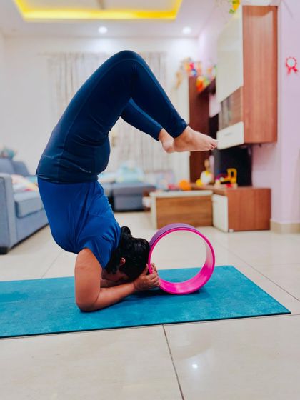 Inversion love. A student practices scorpion pose with a wheel for support. While it may not be the final form, every attempt is a step forward in building strength and confidence.