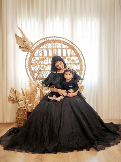 A stunning mother-child portrait in our black ballgown. The boho peacock chair adds a beautiful textural contrast to the sleek dress.