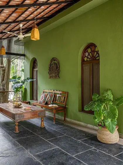The long, shaded verandah outside the suites is furnished with antique benches, providing a perfect spot to relax and enjoy the garden views.