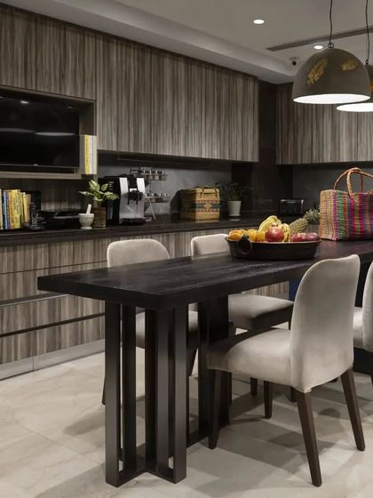 The large kitchen in the Caitriona apartment is designed for a food connoisseur. It features hardwood countertops with ebony inlays, custom pullout trays for organized storage, and a durable laminate finish, combining high style with practical functionality.
