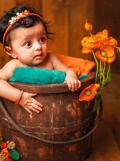A curious look from this little one. The combination of the dark wood, bright flowers, and teal blanket creates a lovely color palette.