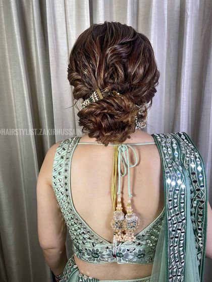 A soft, textured updo with highlights, perfect for a cocktail party or reception. The style is accented with a delicate, jeweled hair accessory that adds a touch of sparkle.