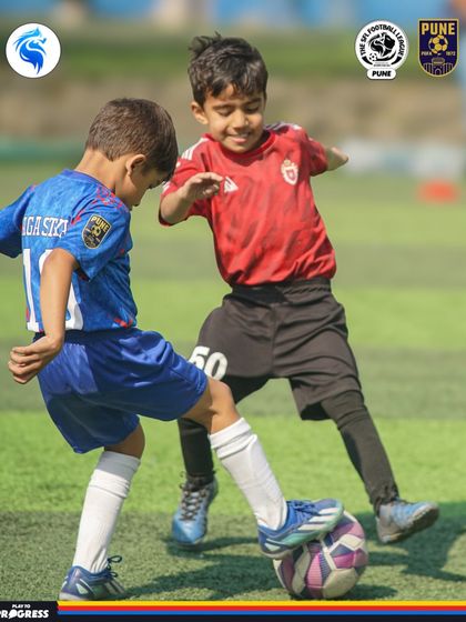 Two young players smiling as they compete. We believe in fostering a love for the game alongside a competitive spirit.