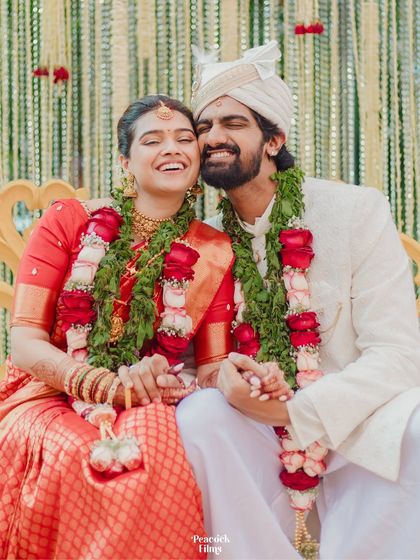 An iconic candid moment from a South Indian wedding, capturing the bride's ecstatic laugh as she embraces her new husband.