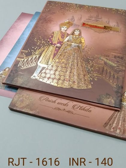 A beautiful invitation with a gold-foiled illustration of a royal couple. The card has a rustic, textured background and includes matching inserts for a complete set.