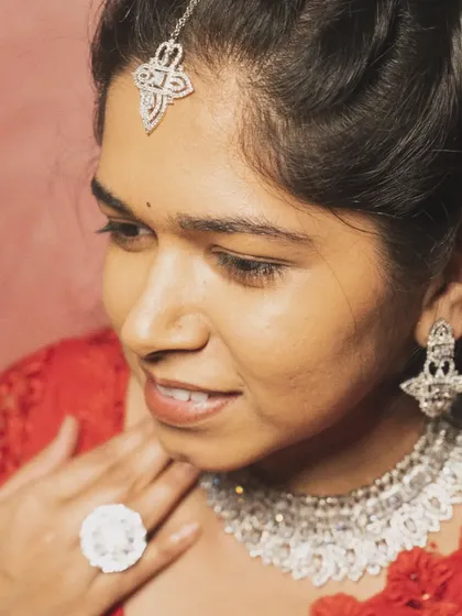 A close-up portrait showcasing the intricate design of the AD choker, earrings, and maang tikka. This set is designed to make you feel like a star.