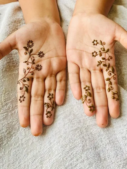 For those who love simplicity, a minimalist design can be just as beautiful. This delicate floral vine gracefully adorns the fingers and palm, offering an elegant and understated look.