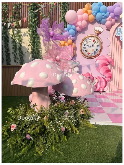 Whimsical mushroom props covered in flowers add to the magical garden feel.