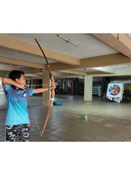 A young woman practices her shot, demonstrating the strength and stability she has developed during the course.