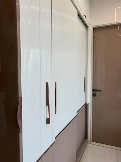 A close-up of the wardrobe's textured laminate finish and sleek handles.